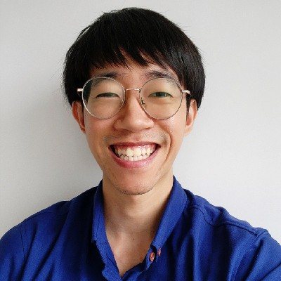 Lance Tan smiling, wearing glasses and a blue shirt.